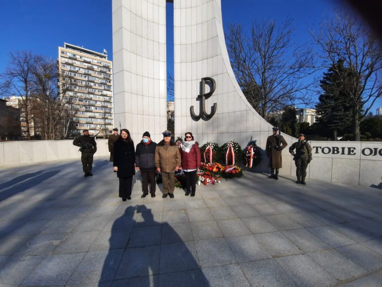 Grafika przedstawia osoby przy pomniku Armii Krajowej.