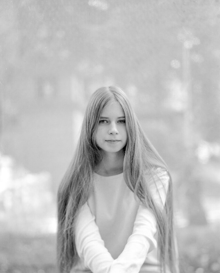 Czarno-biały portret długowłosej dziewczyny.