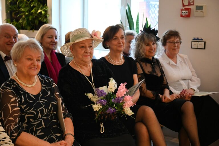 Kobiety ubrane elegancko siedzą w pierwszym rzędzie na widowni